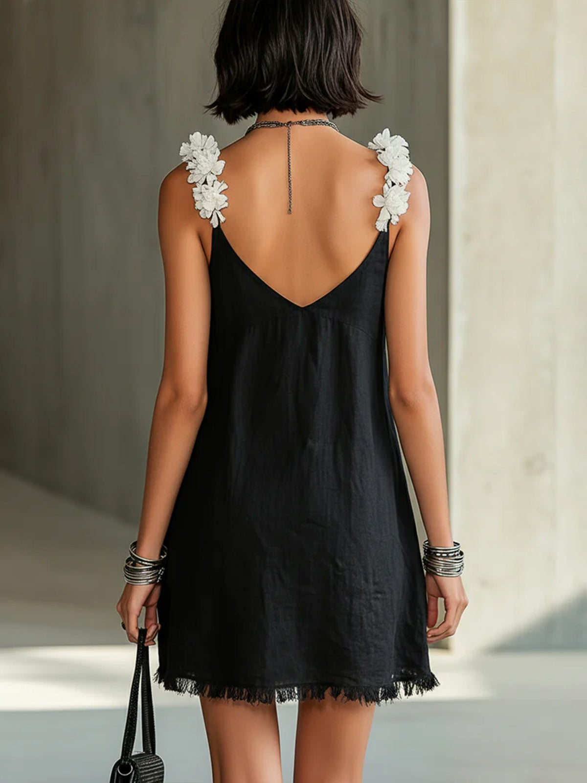 Black mini dress with V-neckline and floral straps
